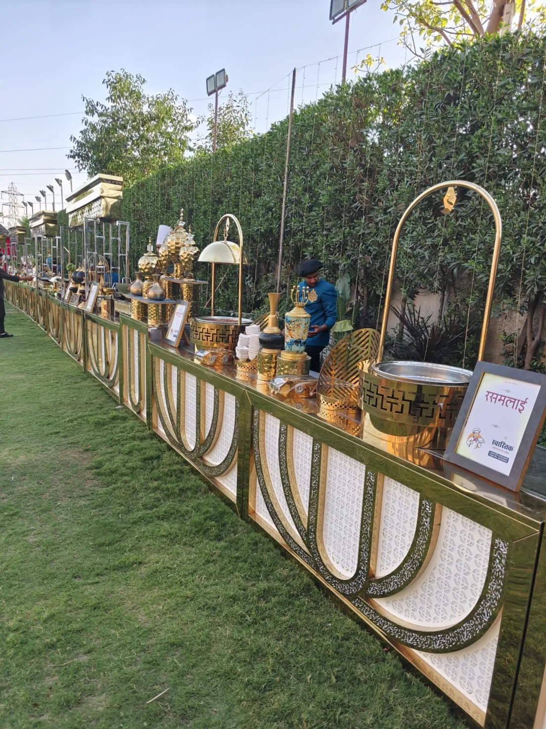 Long outdoor Indian wedding buffet with decorative serviceware