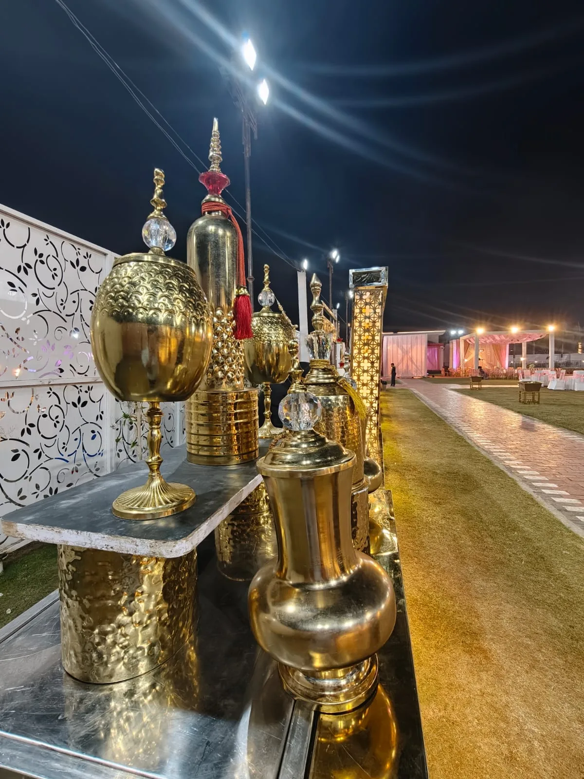 Golden decorative catering vessels at a night event