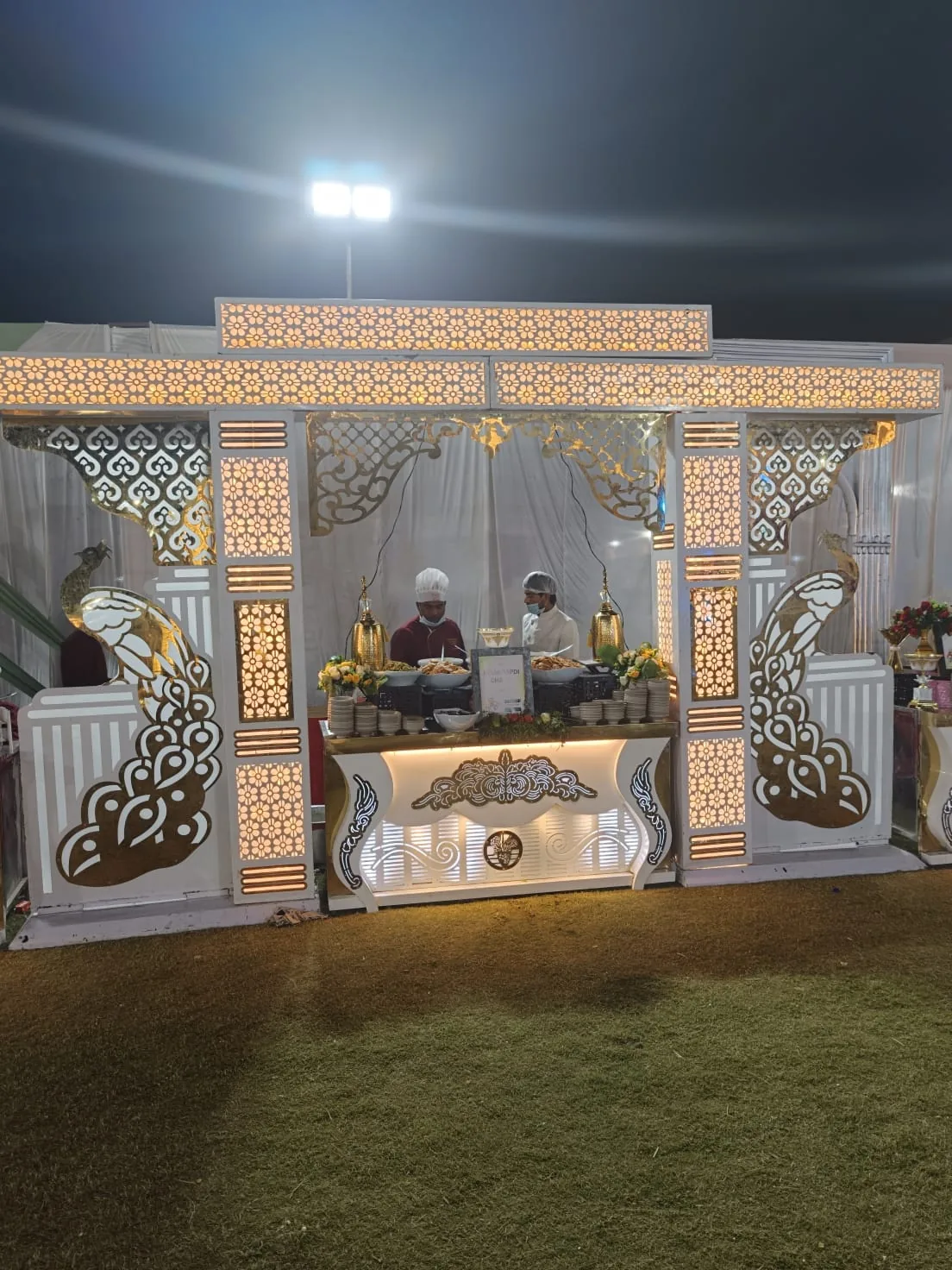 Illuminated vegetarian live counter framed with peacock motifs