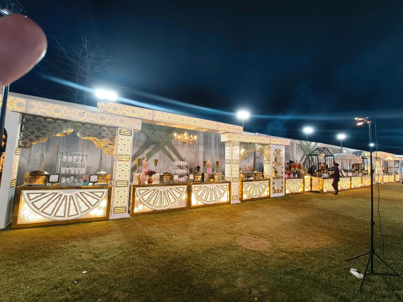 Expansive illuminated catering counters at a night event